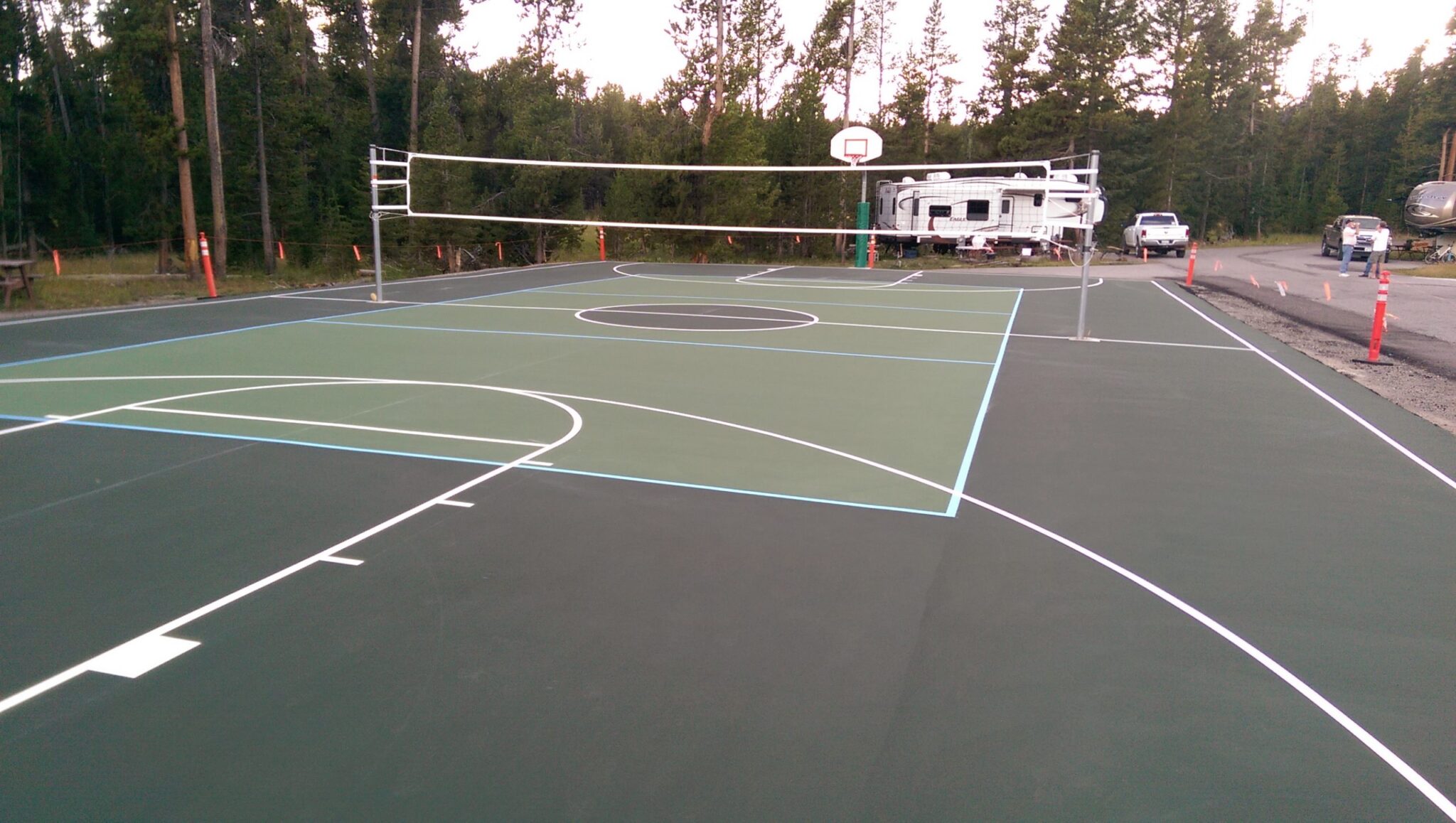A new court in a campground with lines for volleyball and basketball.