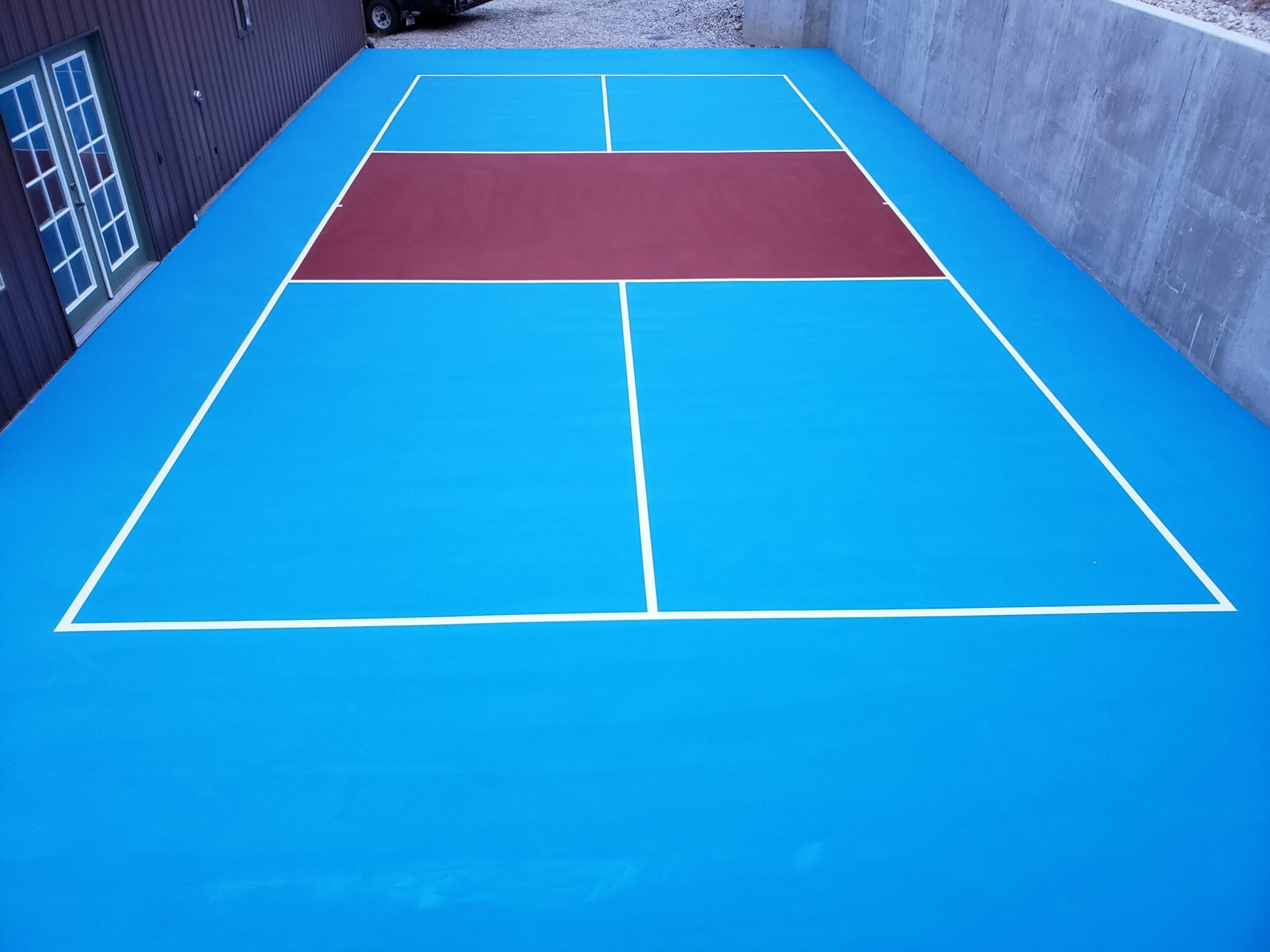 A new pickleball court with blue, maroon, and white colors.