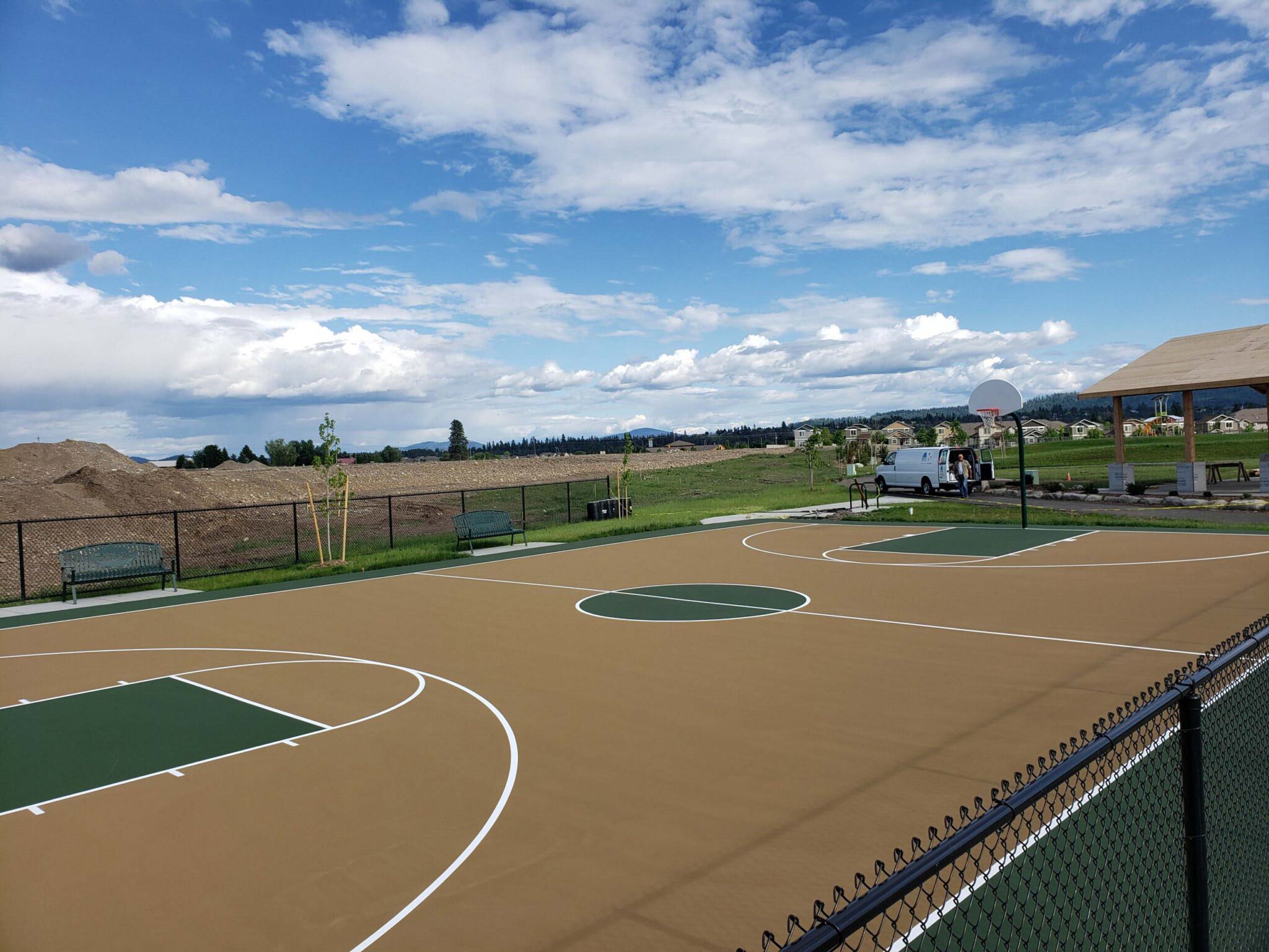 A new basketball court with a tan, green, and white color scheme.