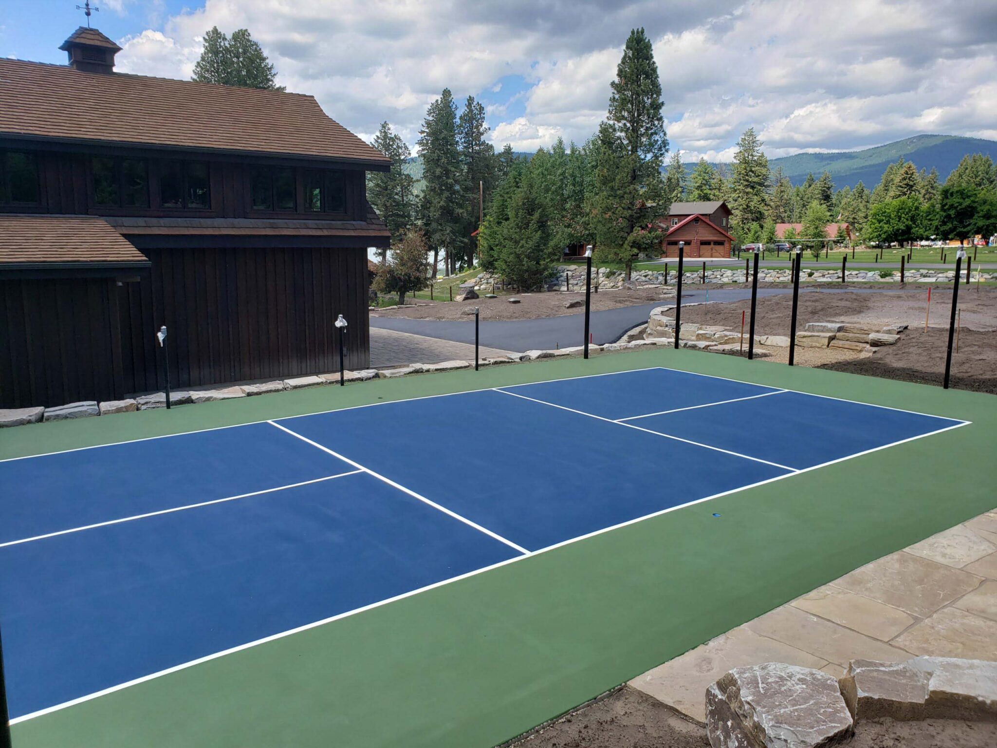 New pickleball court with a mountain backdrop and a green, blue and white color scheme.