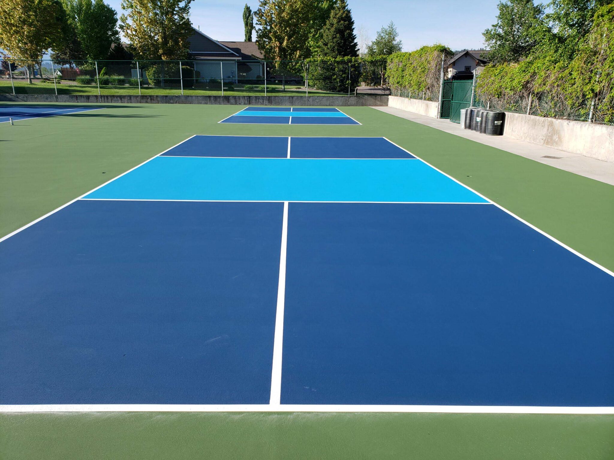 New pickleball courts including fencing and a green, blue and white color shceme.