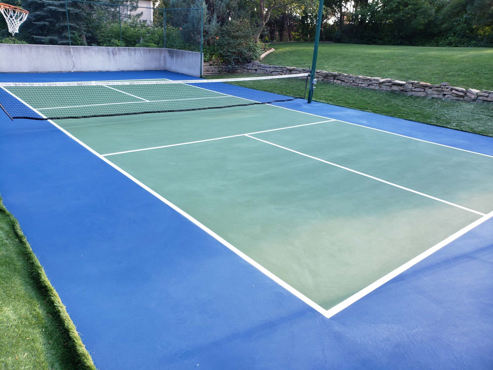New pickleball court with a green and blue colored surface and white lines.